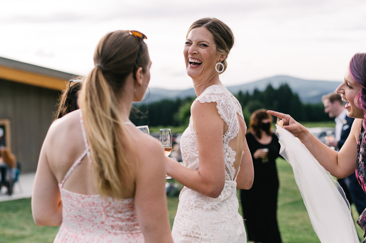  Bride laughing at camera with wedding guests 