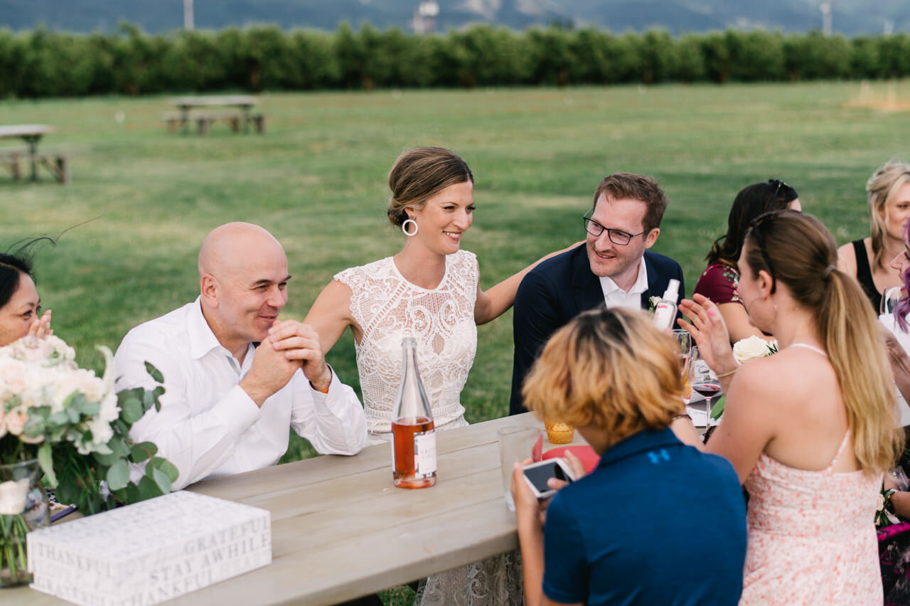  Bride throws arms around guests at elopement dinner at grateful vineyards 