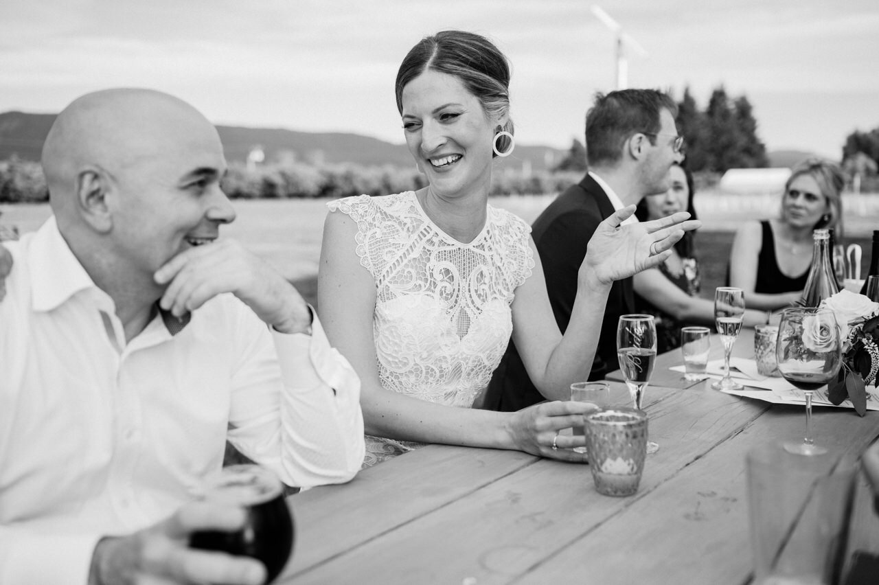  Bride talking at picnic table with wedding guests 