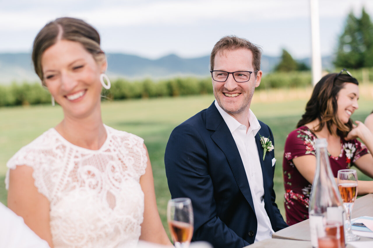  Groom smiling at wedding reception with rose wine on the table 