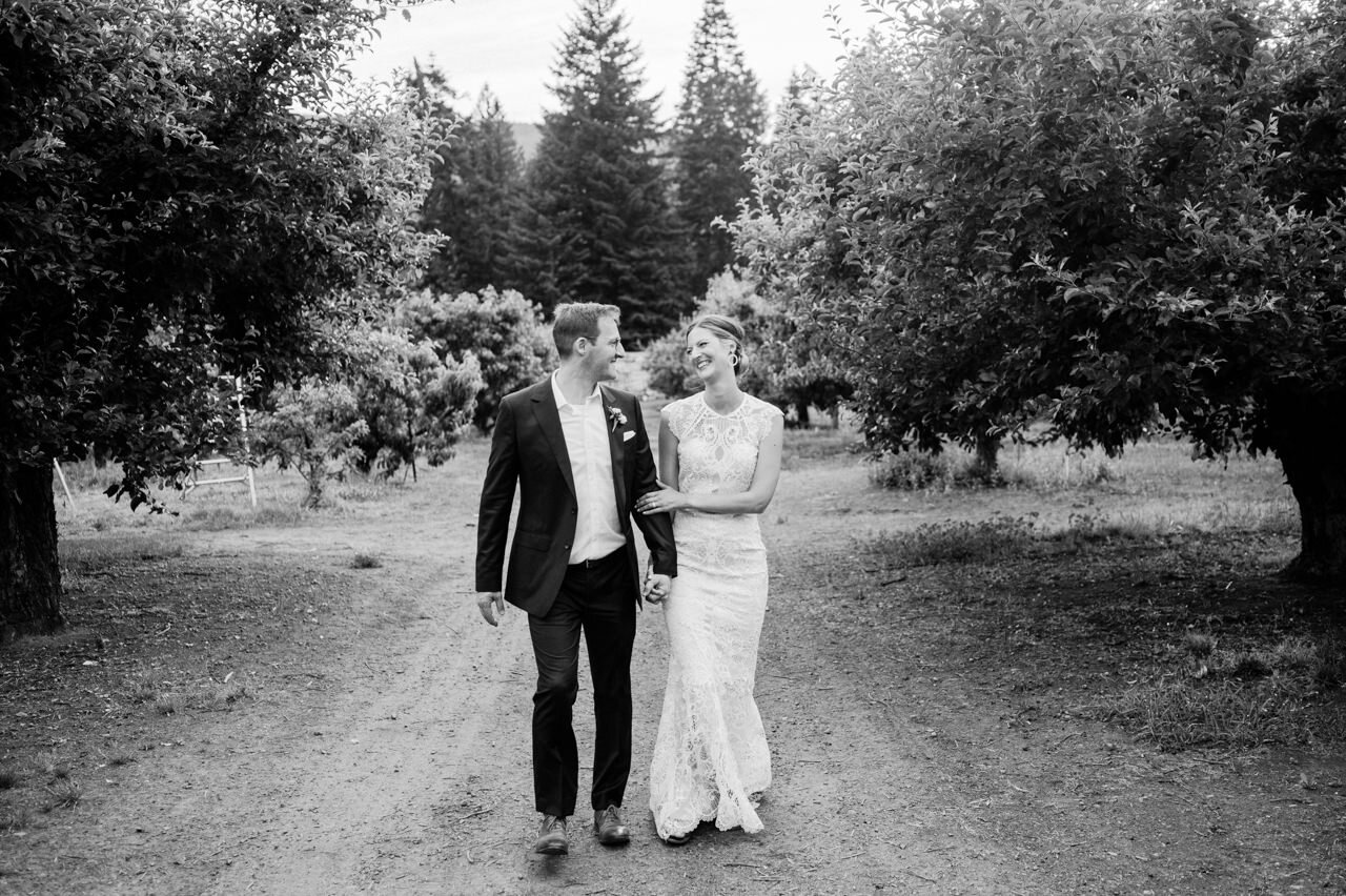  A walk together holding arms down a dirt road among orchards 