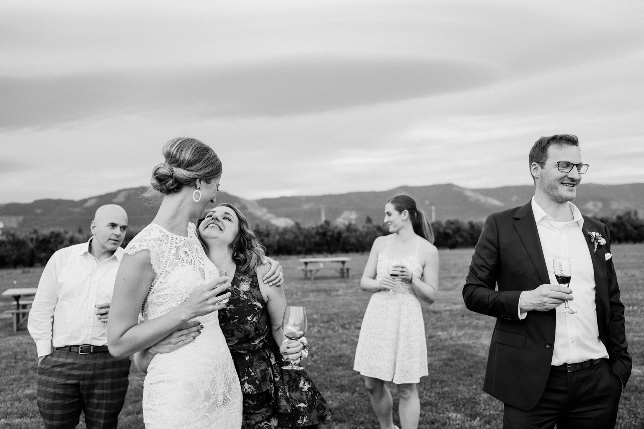  Candid moment of guests and bride and groom drinking in hood river valley 