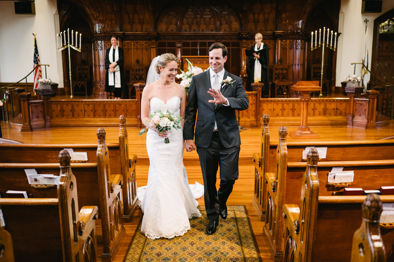  Bride and groom walk down church aisle just married smiling with empty covid cathedral 