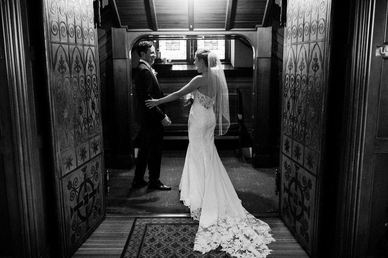  Through the church doors, bride and groom congratulate each other at being just married with excitement 