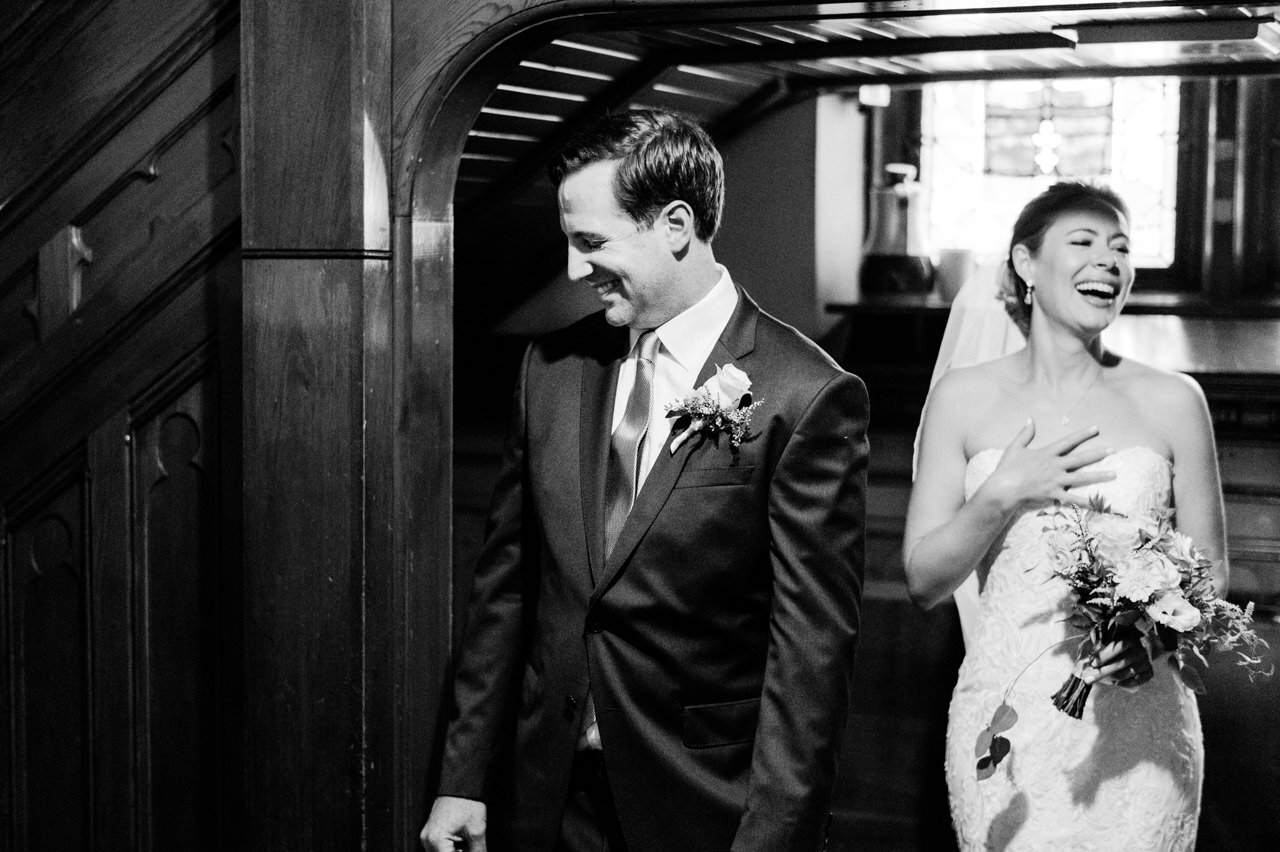  Close up of groom and bride laughing after just being married in black and white 