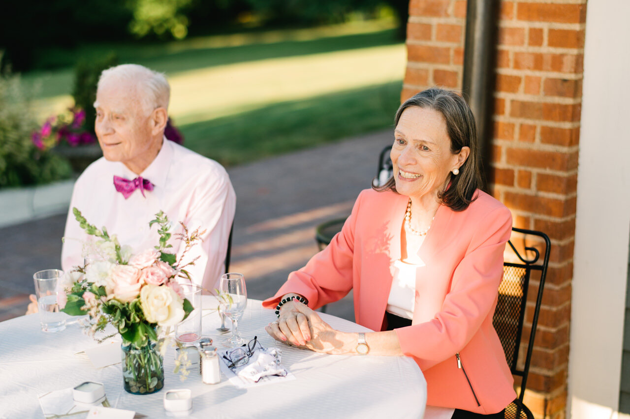  Happy parents of wedding couple at patio wedding table 