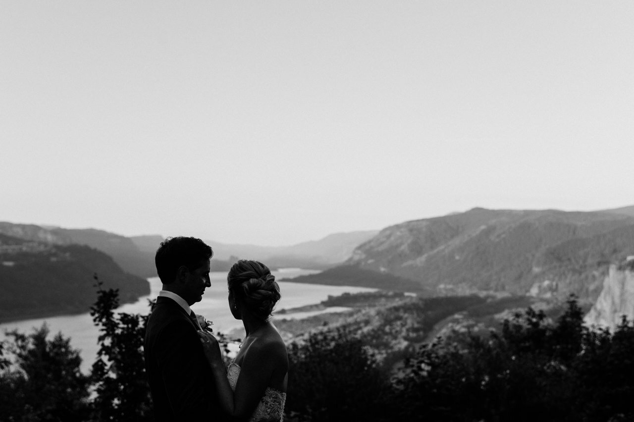  Bride looks at Columbia gorge viewpoint in black and white photograph 