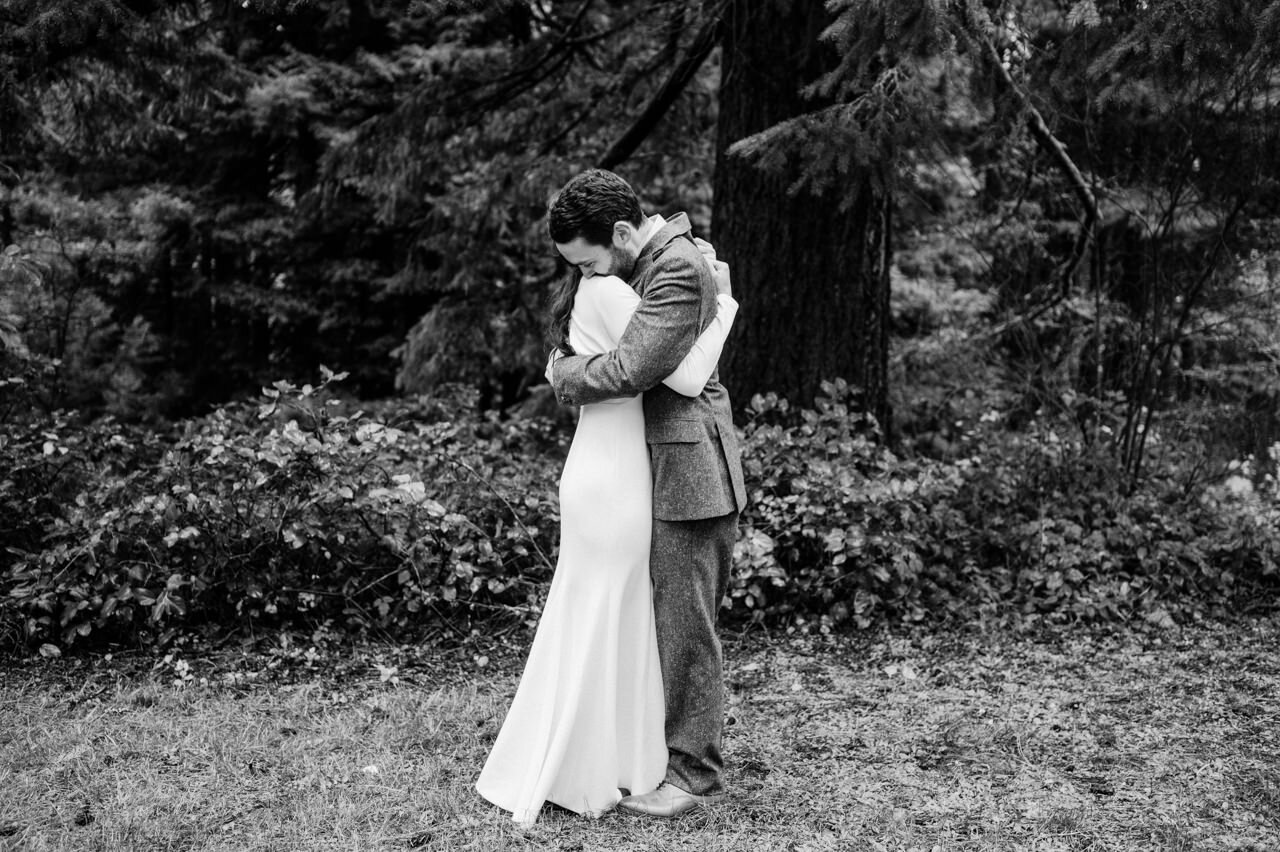  Bride and groom embrace during first look moment in black and white photograph 