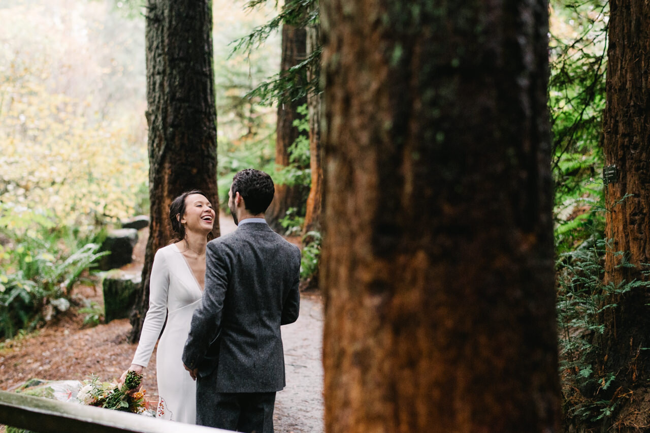  Bride laughing with groom in redwood grove in portland 