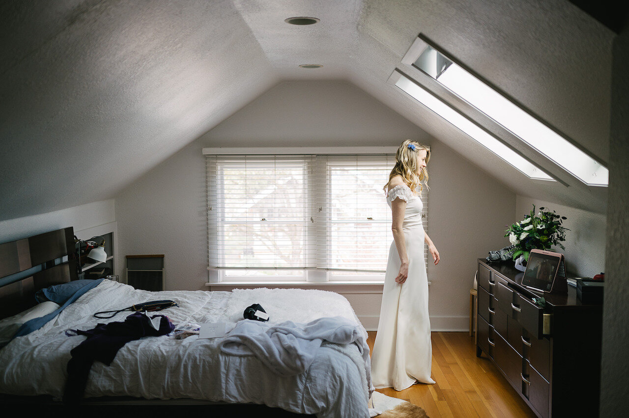  Bride in portland attic on FaceTime with mom stands under skylight 