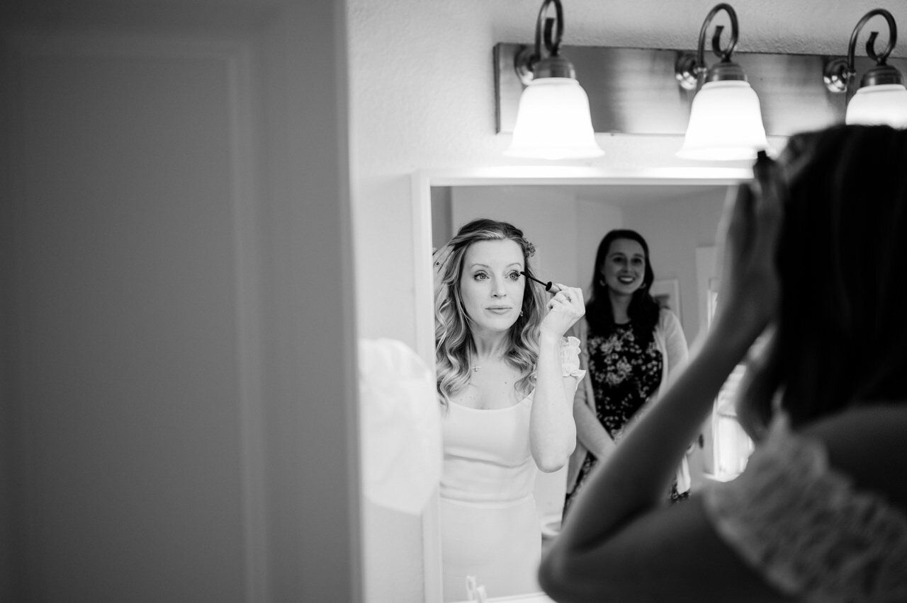  Bride applies mascara in bathroom getting ready 
