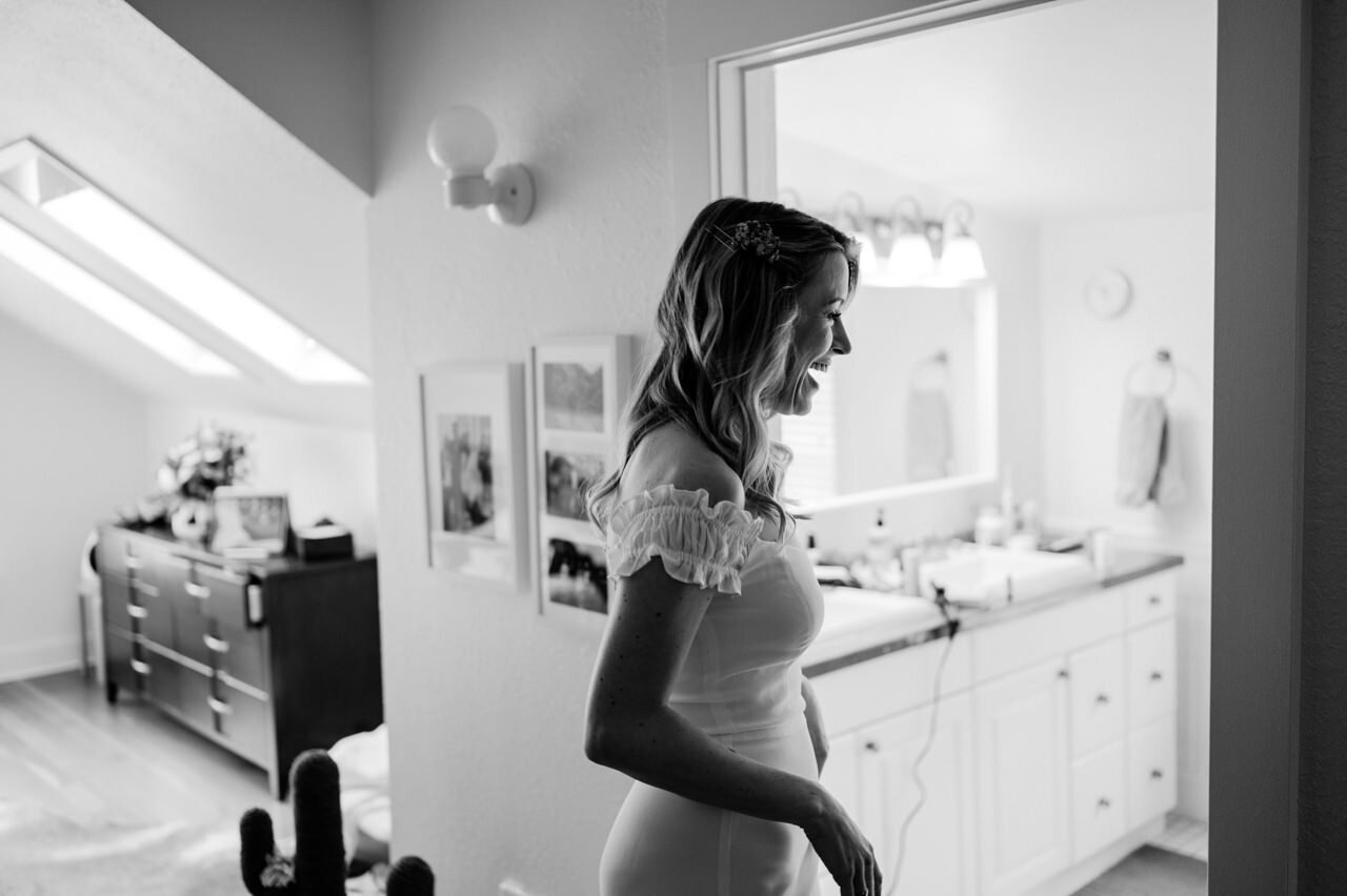  Bride laughs as she walks into bathroom in candid moment 