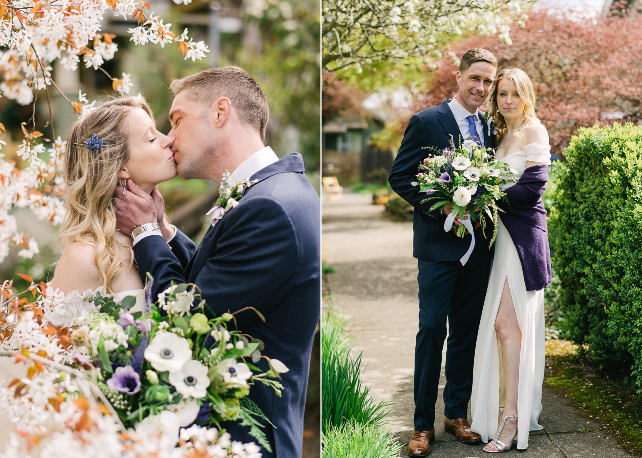  Groom in blue suit kisses blonde bride while holding her neck surrounded by blooming white flowers 