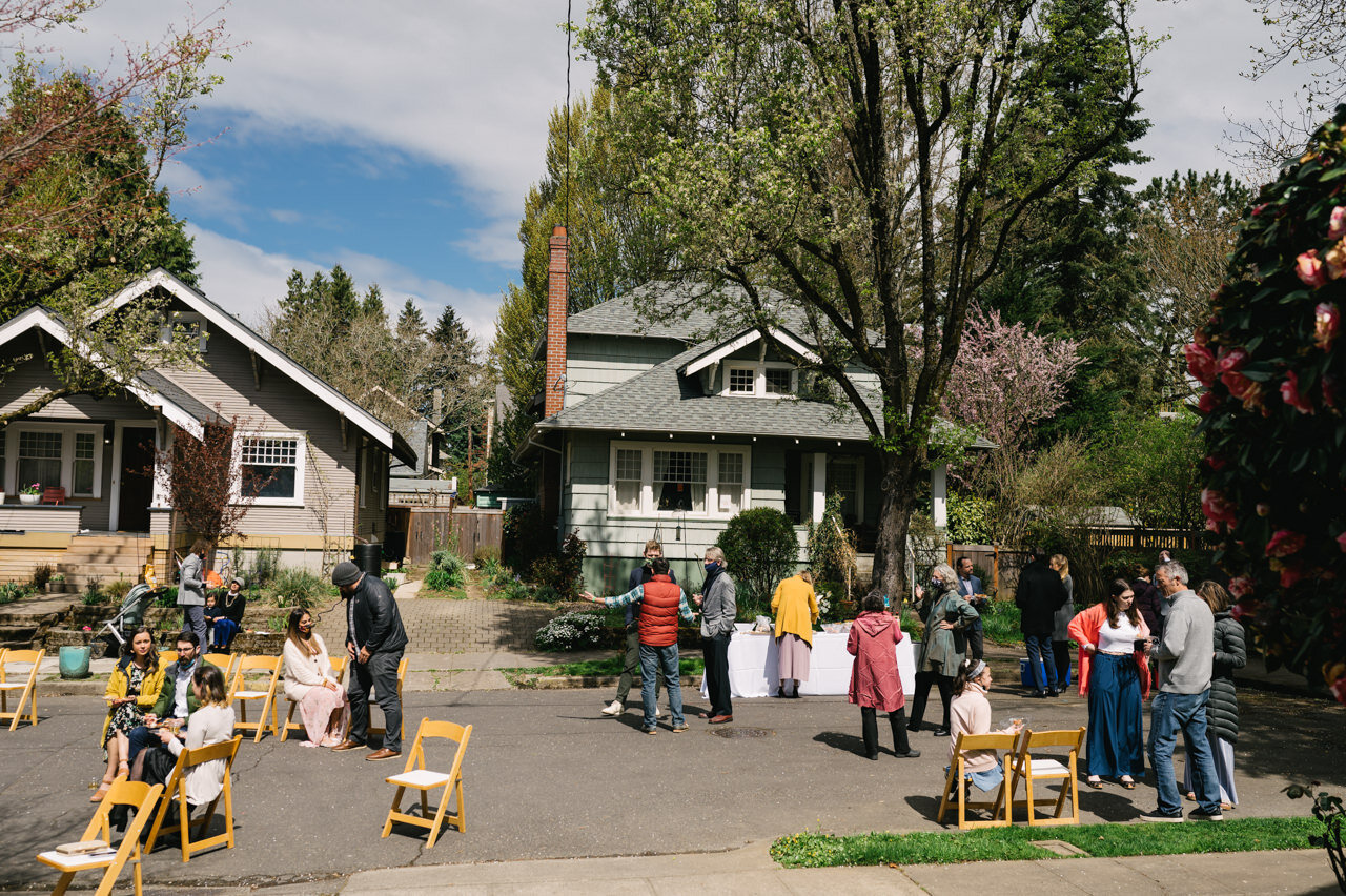  Spaced out chairs on dead end street in portland neighborhood while guests celebrate wedding 