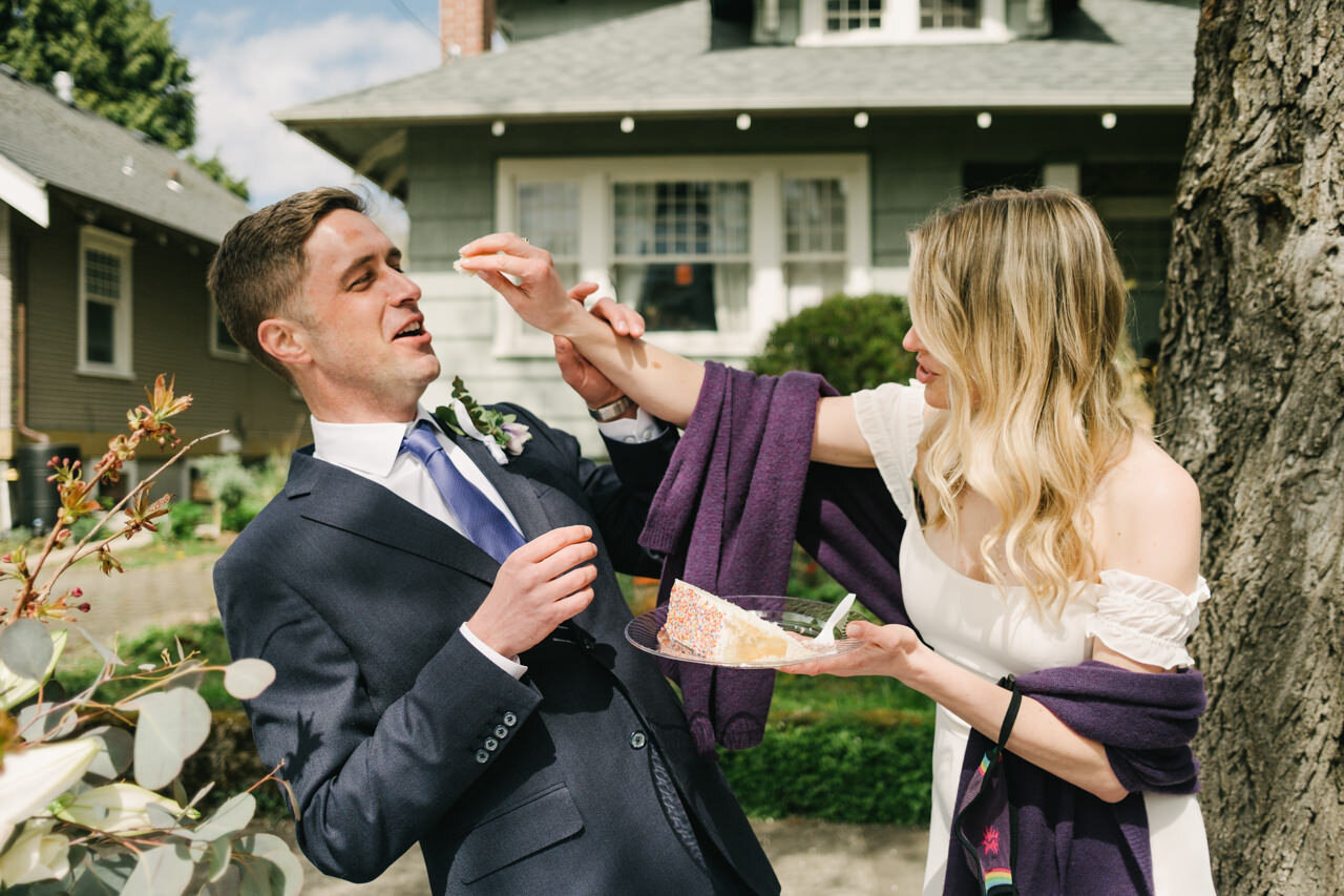  Bride tries to put cake on grooms nose while they feed each other 