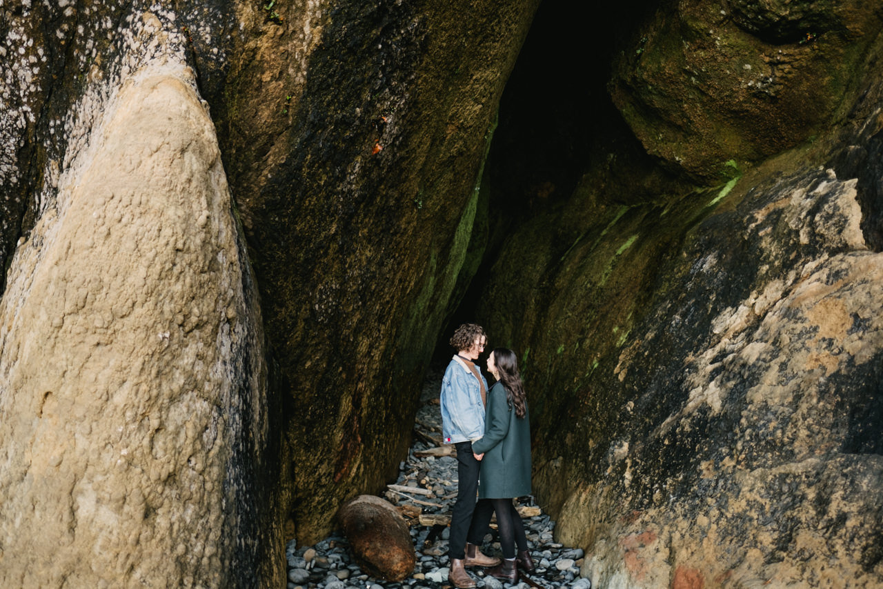  Couple stands together in slanted Oregon rock cave 