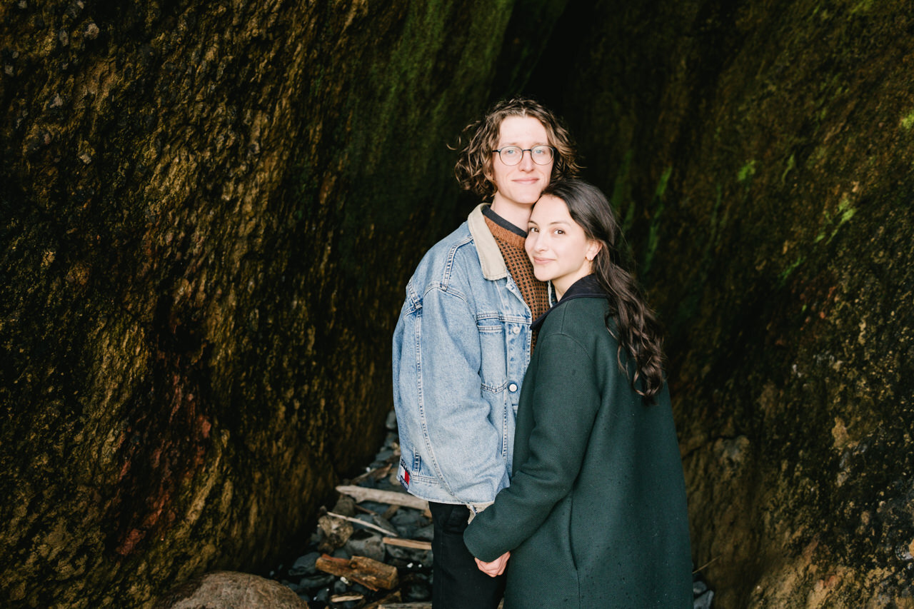  Couple portrait in rock cave surrounded by greens and browns 
