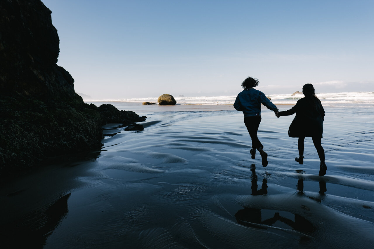  Engagement photograph silhouette running along Oregon coastline 