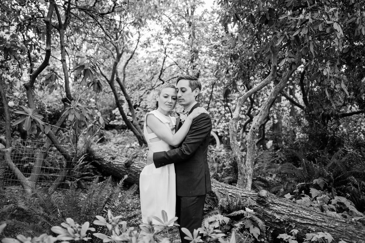 Serene portrait of bride and groom standing in grove of rhododendrons in black and white 
