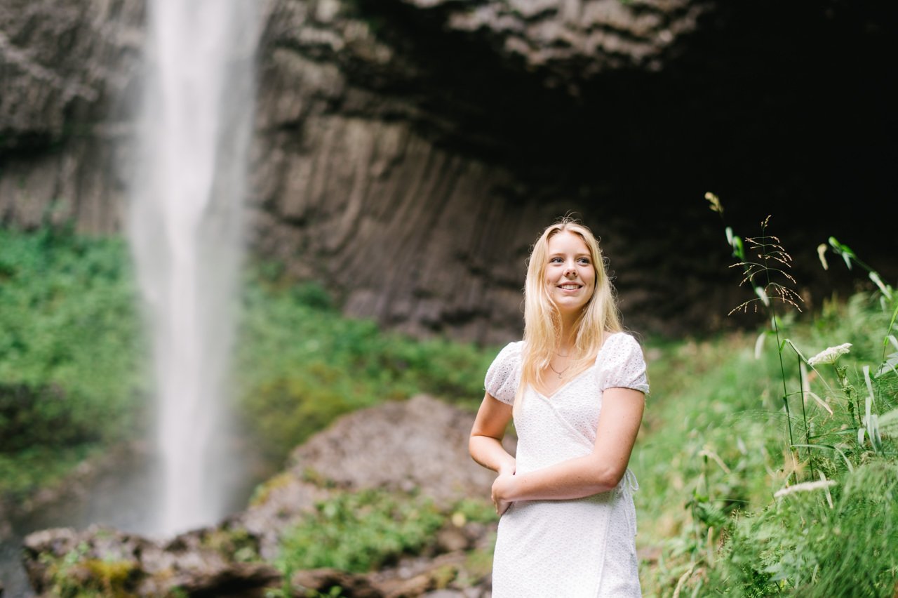  Girl leaning on hip looks away from waterfall in Columbia Gorge 