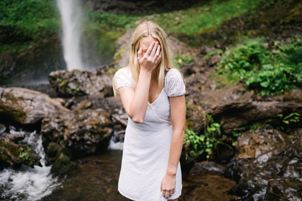  Outtake of senior girl holding her face in hands in embarrassment 