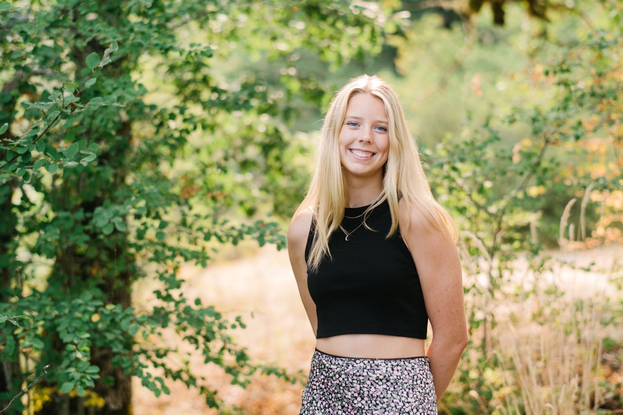  Senior portrait of smiling blonde girl in oak trees 