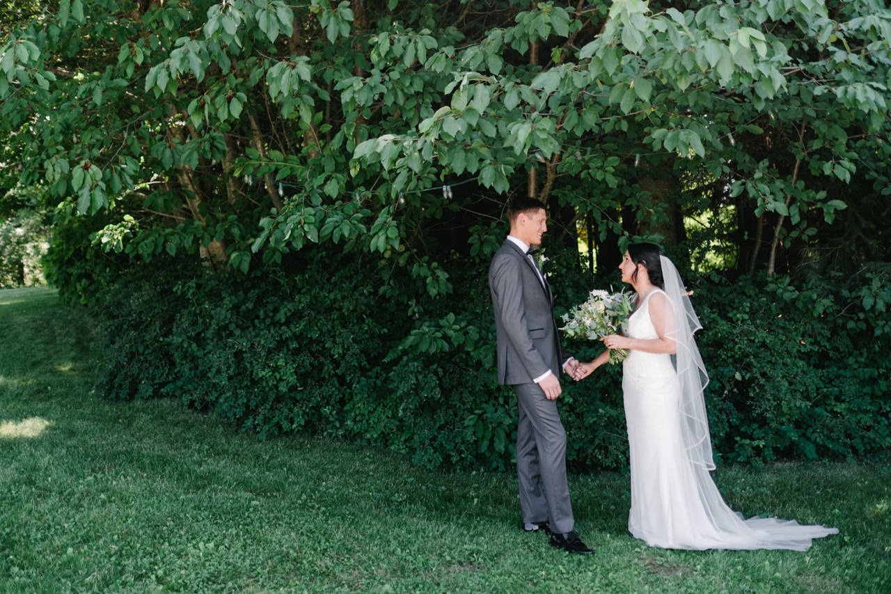  Bride and groom under trees in first look moment at mt hood organic farms 