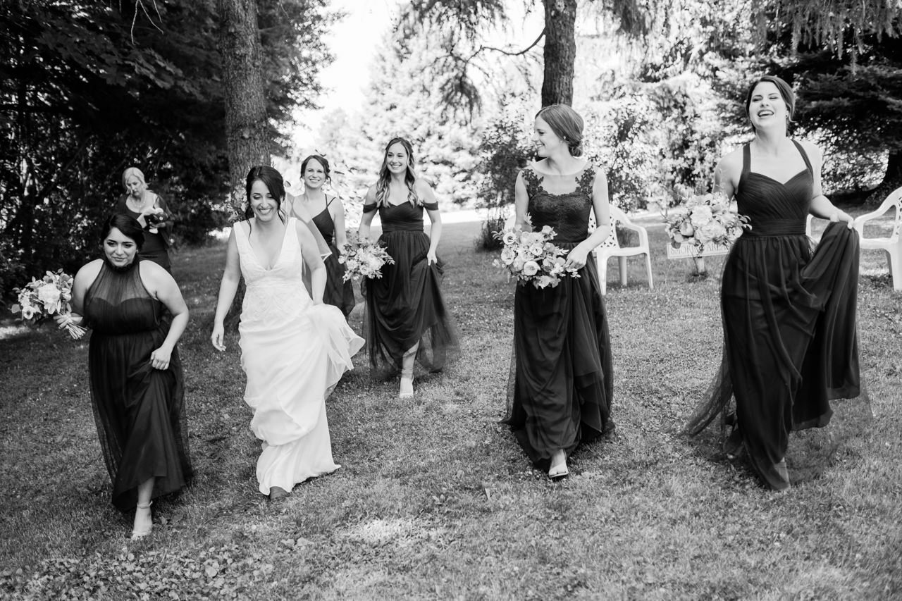  Black and white candid photo of bridesmaids returning to ceremony 