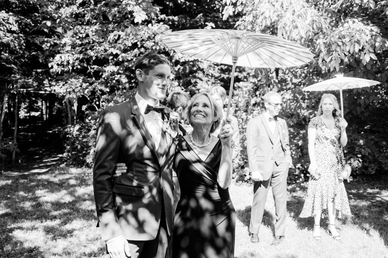  Moment between groom and mother under wood umbrella before the wedding 