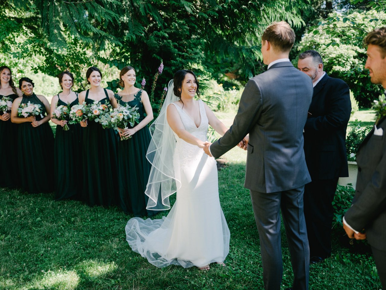  Bride laughs while holding grooms hand at wedding ceremony 