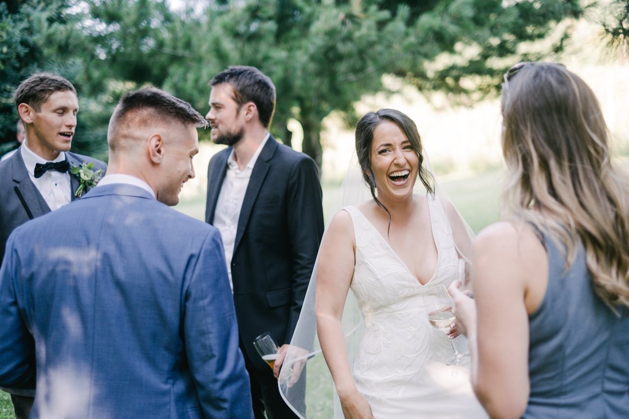  Bride laughs among wedding guests during cocktail hour 