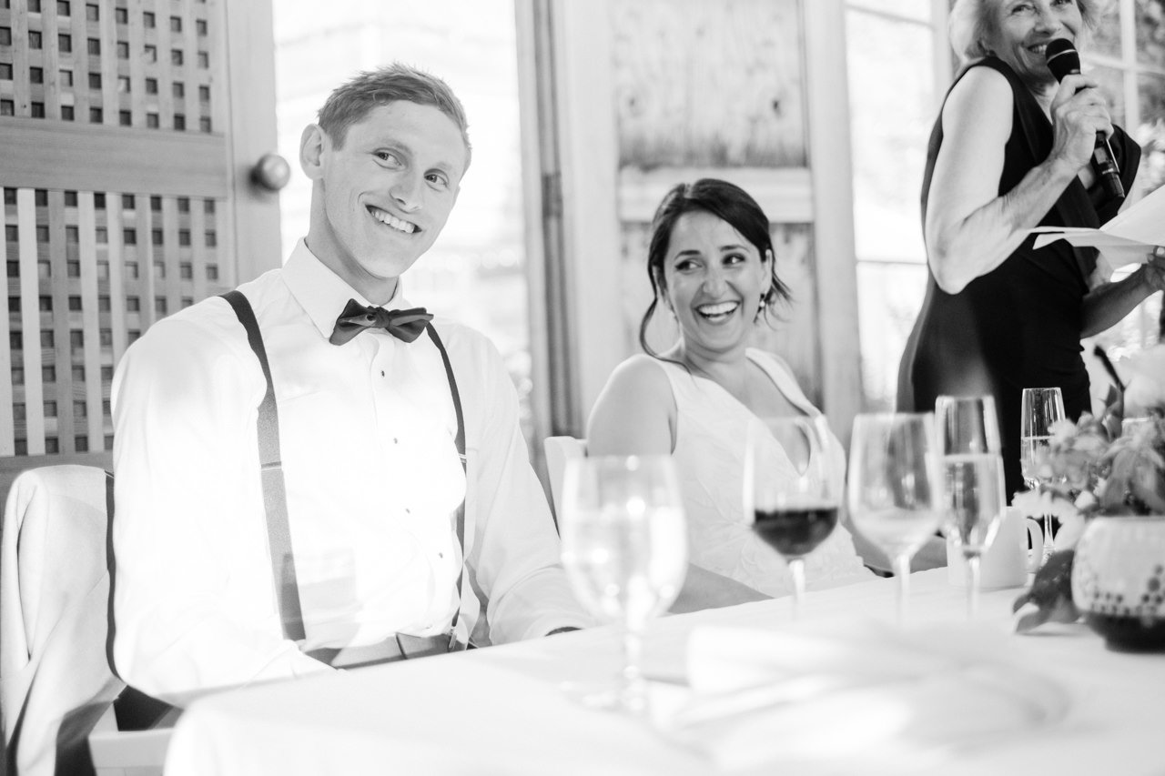  Groom smiles at guests during toast by his mother 