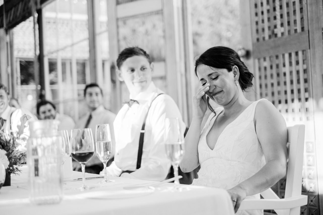  Bride tears up during wedding toasts in black and white photo 