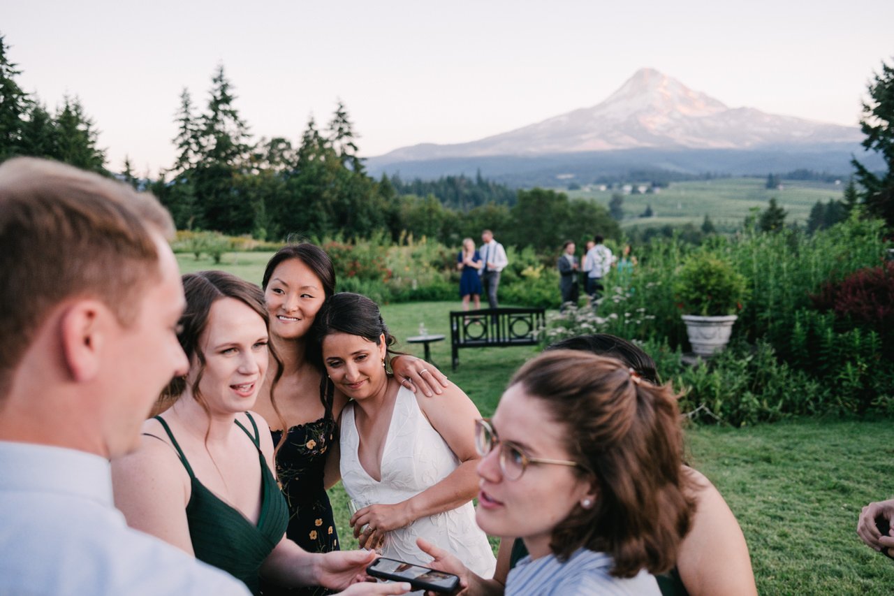  Guests embracing bride on lawn in front of mt hood 