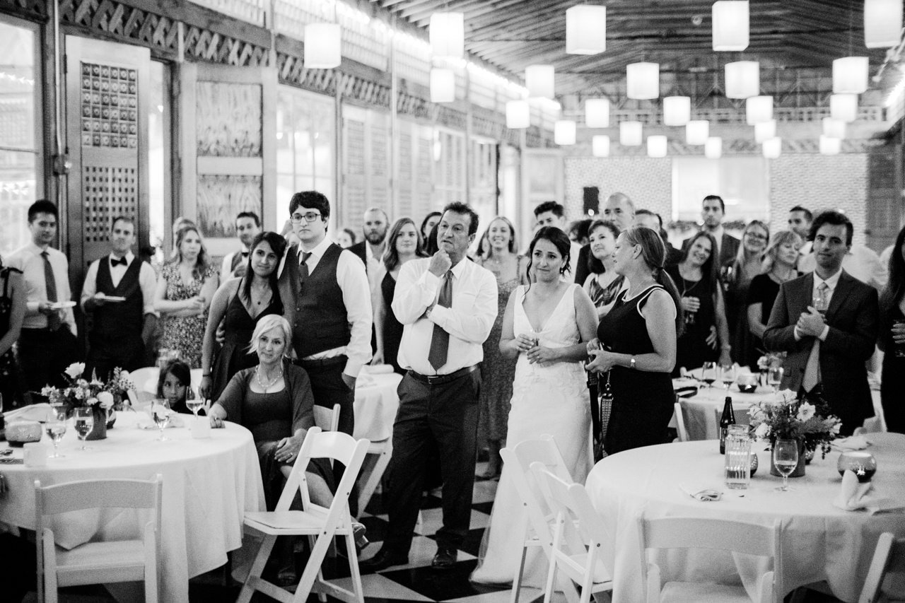  Bride watches groom dance with his mother with wedding guests 