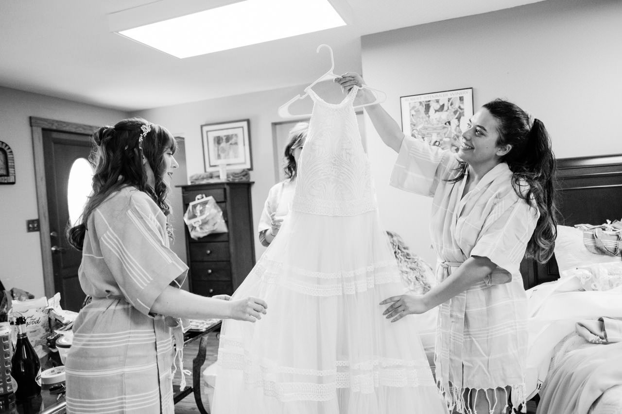  Bride holds up shoulder cut wedding dress 