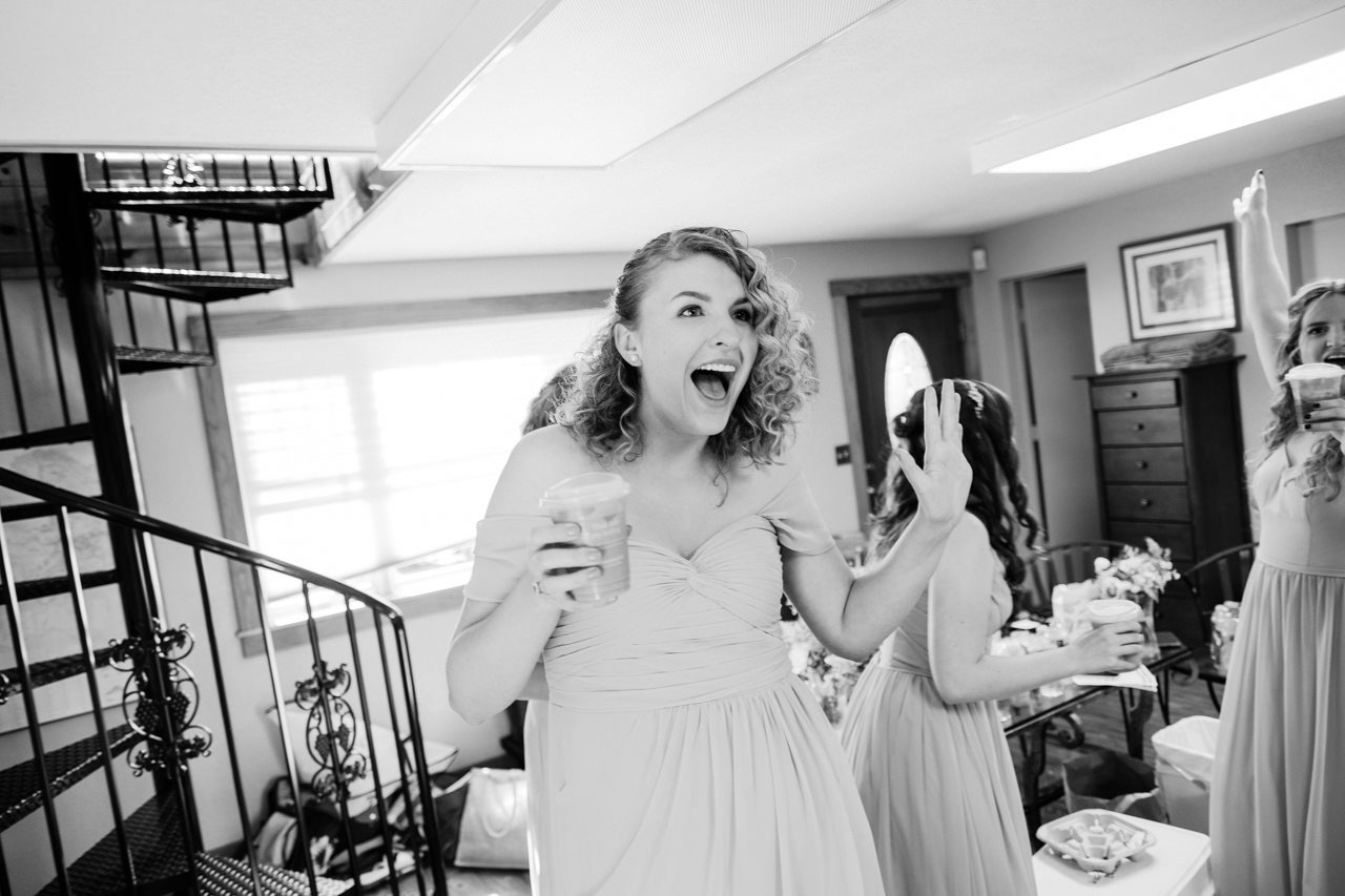 Bridesmaid laughs and dances near spiral staircase 