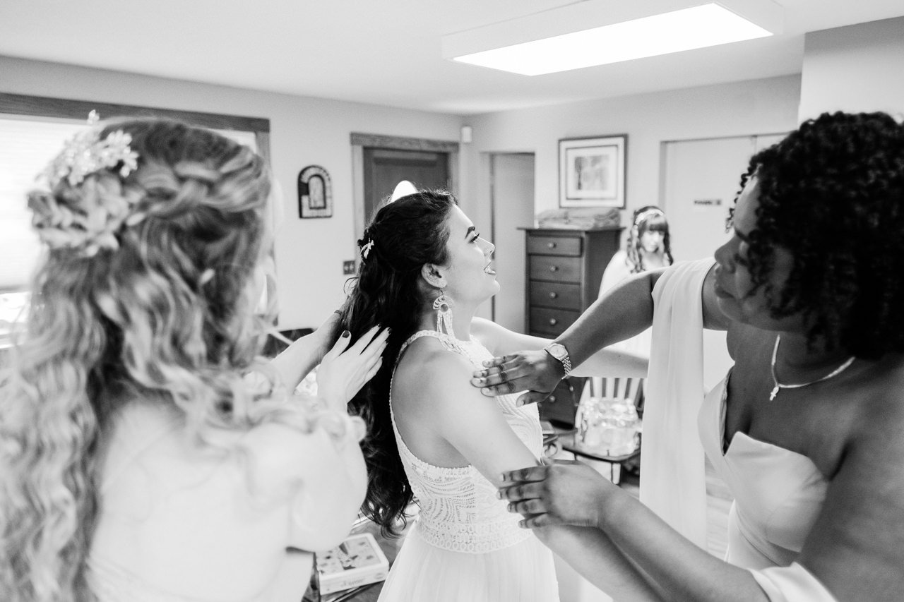 Bridesmaids rub sunscreen on bride while getting ready 