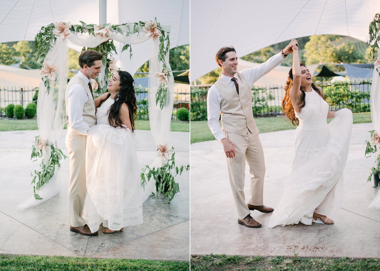  First dance with couple dancing in front of floral wedding arch 