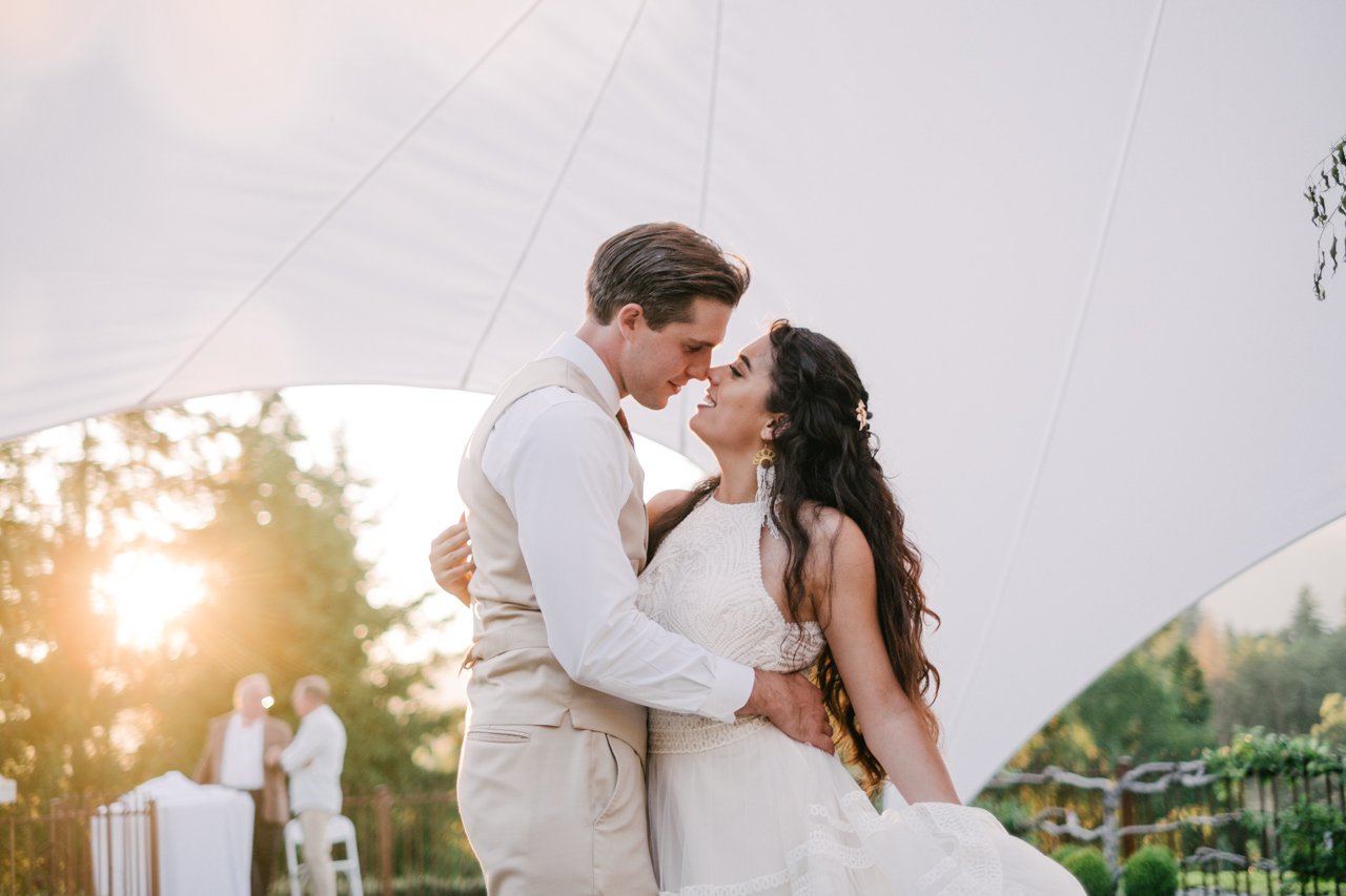  Bride and groom pull each other close during romantic first dance in golden sunlight 