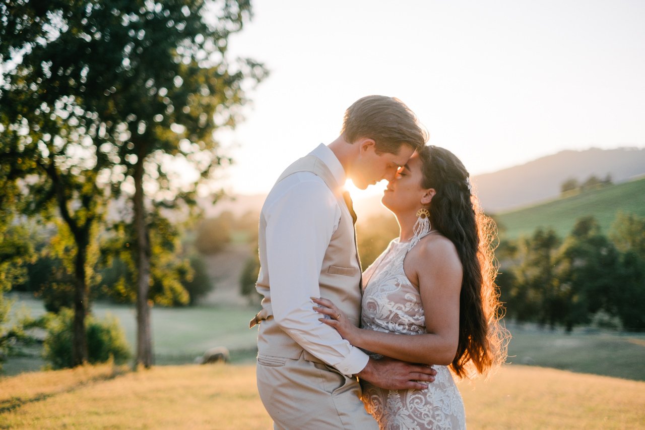 Bride and groom with tan suit almost kiss in golden hour sunlight in southern Oregon Roseburg farm fields 