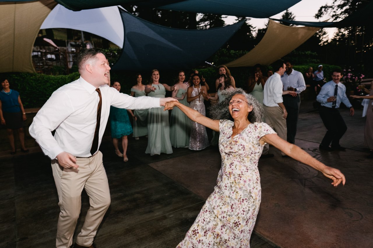  Guest spins mother of bride while she laughs during dance 