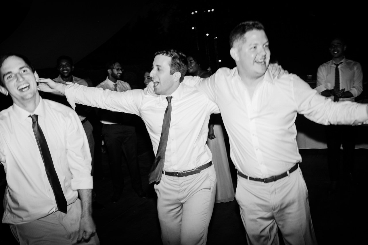 Groomsmen hold shoulders and dance during classic blurry reception photo 