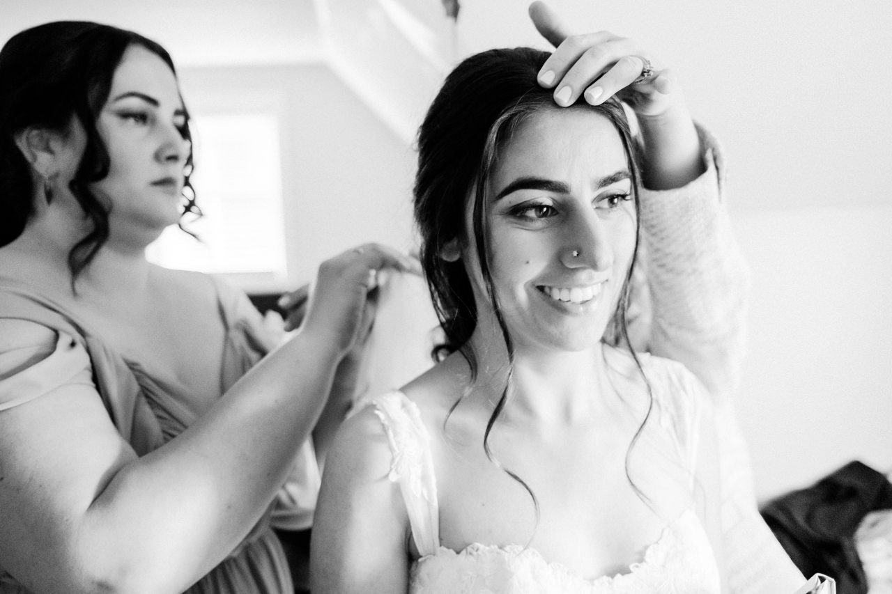  Bridesmaid assists with veil while getting ready 