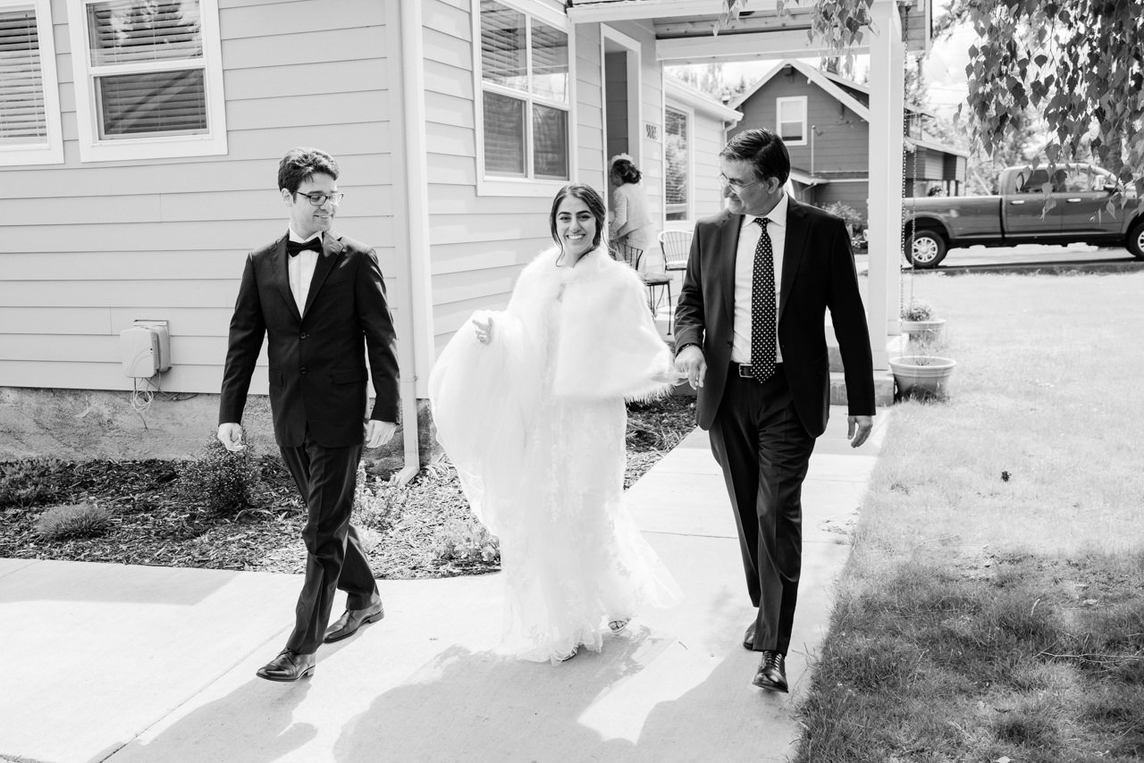  Bride escorted by father and brother to the car 