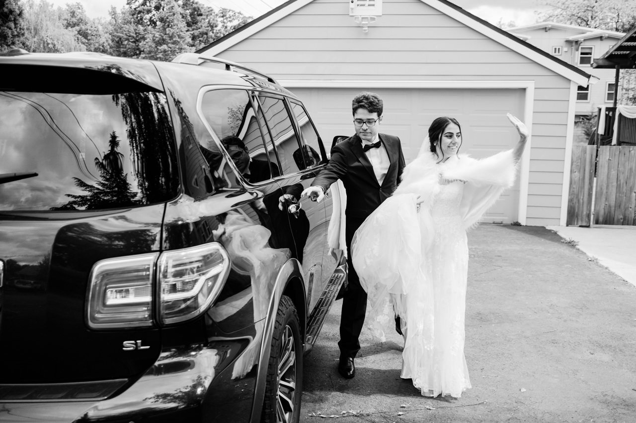 Bride waves goodbye while getting into car 