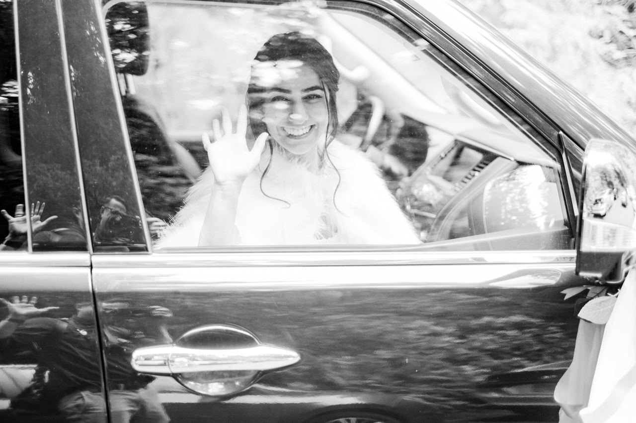  Bride smiles through window after arriving to the ceremony 