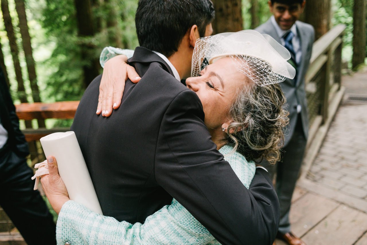  Bride's mother hugs groom before ceremony on redwood deck 