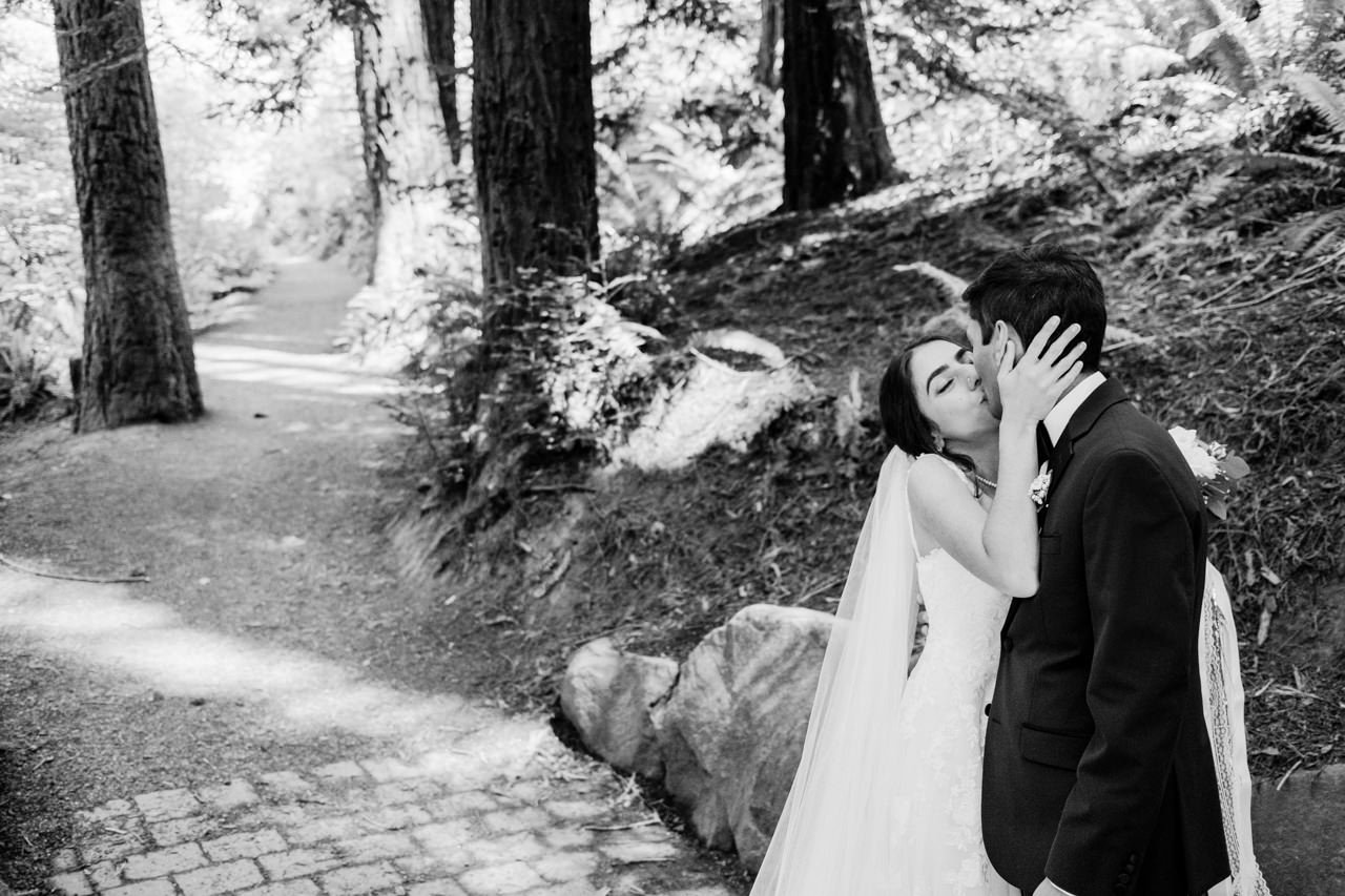  Wedding couple shares kiss after ceremony on Hoyt Arboretum trail 