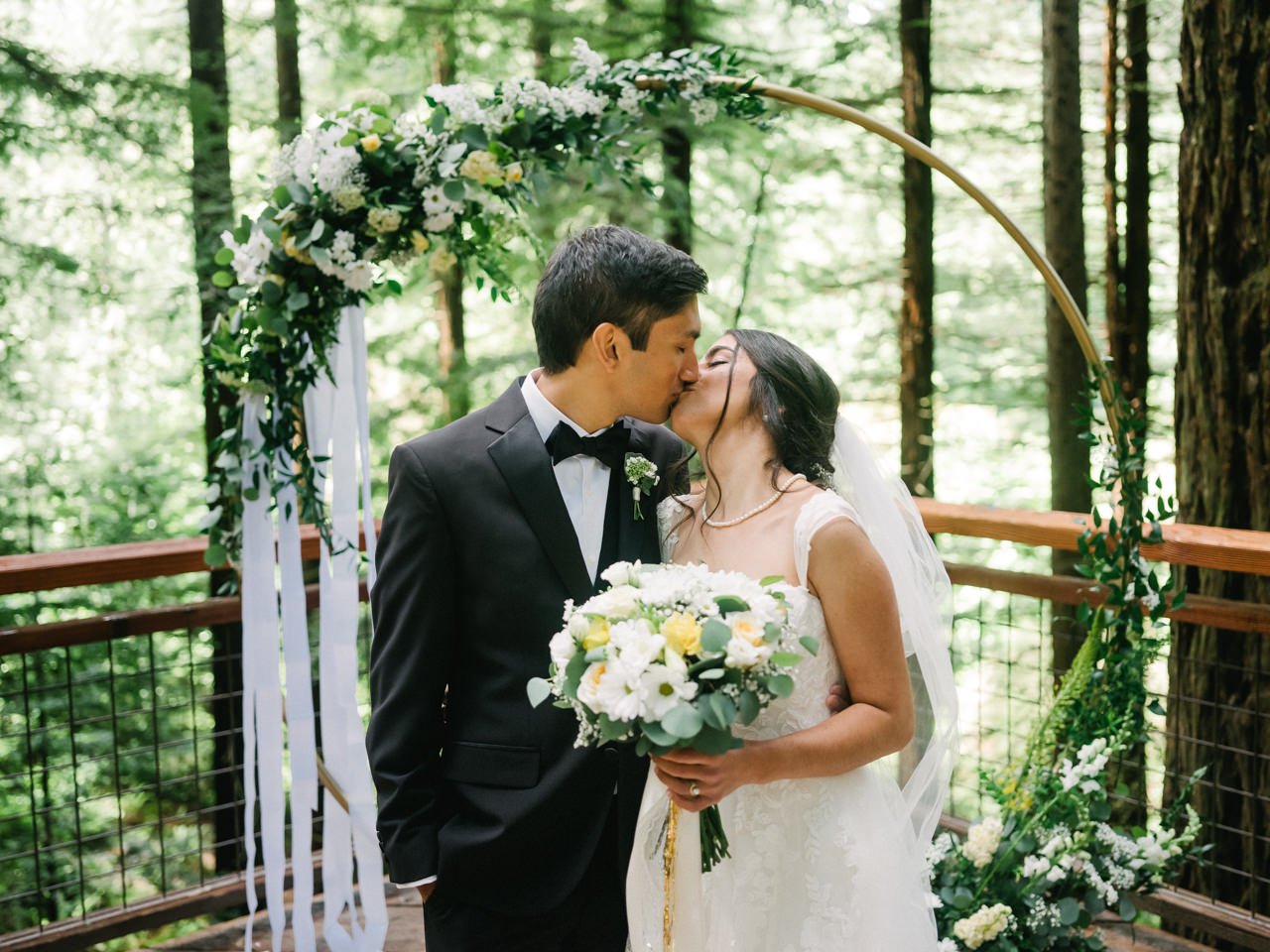  Indian bride and groom kiss in forest wedding ceremony 